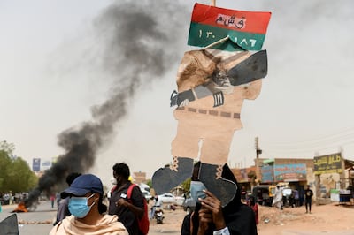 Sudanese protesters hold placards during a rally in June outside the army's headquarters. EPA