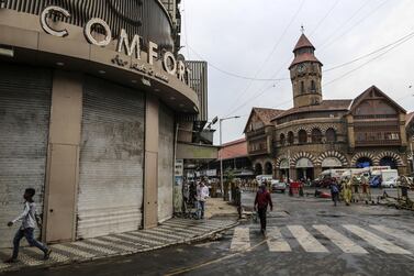 Pedestrians walk along a near-empty street near Mumbai's Crawford Market. India's economic growth has slowed due to a strict lockdown to contain the coronavirus. Bloomberg