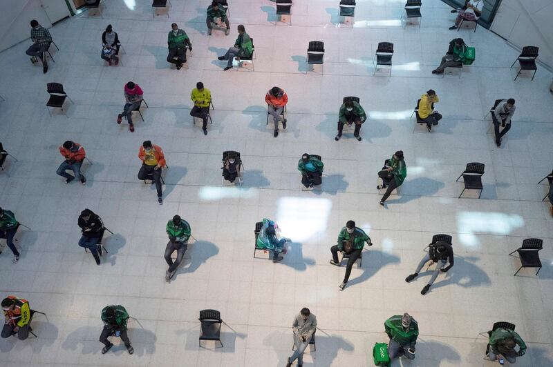 People practice social distancing as they sit on chairs spread apart in a waiting area for take-away food orders at a shopping mall in hopes of preventing the spread of the coronavirus in Bangkok, Thailand. AP Photo