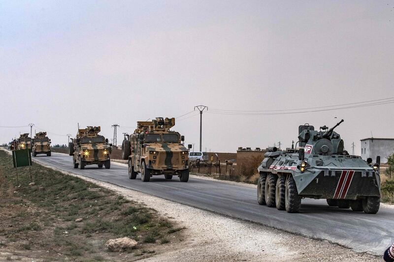 Russian (front) and Turkish military vehicles patrol in the countryside of Darbasiyah town in Syria's northeastern Hasakeh province on the Syrian-Turkish border. AFP