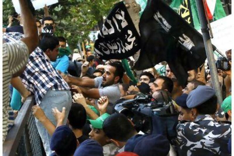 Supporters of the Islamist movement (R), who were demonstrating against the Syrian regime, clash with supporters of Syrian President Bashar al-Assad during their respective protests outside the Syrian embassy in Beirut on August 11, 2011. AFP PHOTO/STR