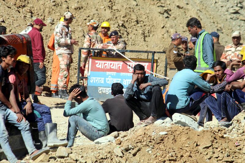 Families and colleagues of the trapped workers have waited at the site for weeks. AP