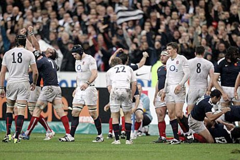 Dejected England players, in white, leave the field after losing 12-10 to France at the Stade de France last year.