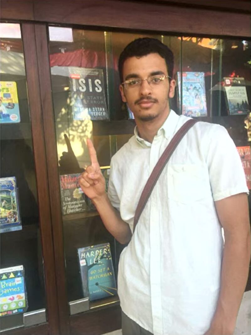 Ismail pointing at an ISIS book.