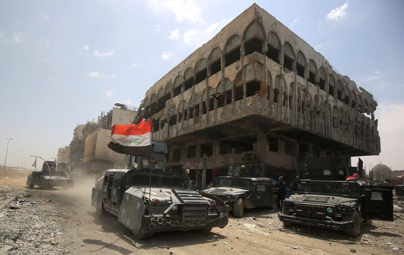 Members of the Iraqi federal police vehicles are seen in the Old City of Mosul on July 8, 2017, as their part of the battle has been declared accomplished, while other forces continue to fight Islamic State (IS) jihadists in the city. / AFP PHOTO / AHMAD AL-RUBAYE