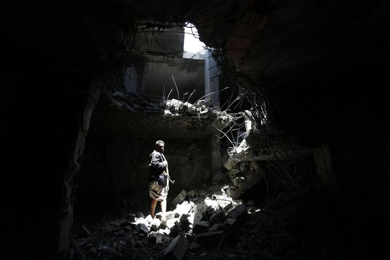 A member of Houthi militia stands amid the rubble of a destroyed house of a senior Houthi leader following airstrikes carried out by the Saudi-led coalition in Sanaa on September 9, 2015. Yahya Arhab / EPA