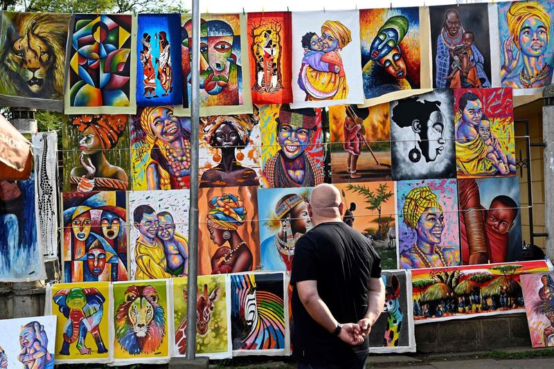 A tourist walks past canvas paintings displayed at the Maasai Market in Nairobi.  APF