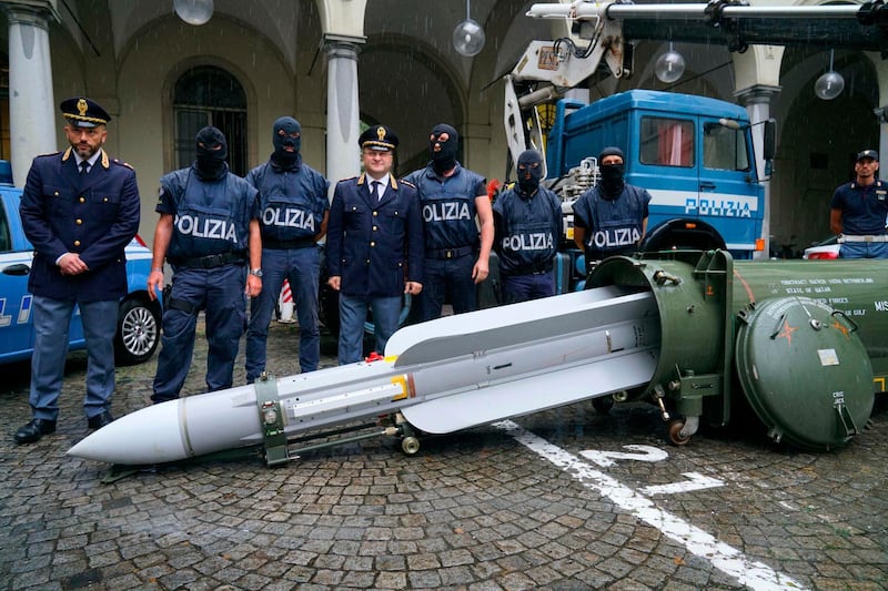 Police stand by a missile seized at an airport hangar near Pavia, northern Italy, following an investigation into Italians who took part in the Russian-backed insurgency in eastern Ukraine, in Turin, Italy, Monday, July 15, 2019. Police in northern Italy have detained three men, including one tied to a neo-fascist Italian political party, after uncovering a huge stash of automatic weapons, a missile and Nazi propaganda. (Tino Romano/ANSA via AP)