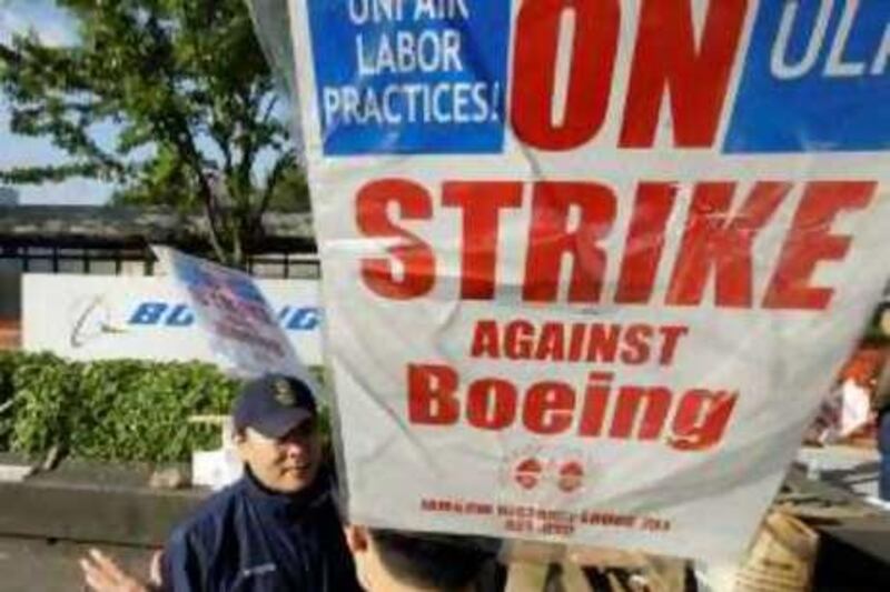 **FILE** In this Oct. 8, 2008 file photo, striking Boeing Co. workers Kenny Toyoji, of Redmond, Wash., left, talks with Michael Mai, right, of Seattle, as they picket near Boeing Field Wednesday, in Seattle. Airplane maker Boeing Co. said Wednesday, Oct. 22, 2008, its third-quarter profit tumbled about 38 percent as a Machinists' strike and supplier production problems hurt results. (AP Photo/Ted S. Warren, file) *** Local Caption ***  NYBZ174_Earns_Boeing.jpg