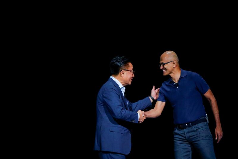 Samsung Electronics President and CEO Dong Jin Koh shakes hands with Satya Nadella, chief executive officer of Microsoft Corp., during the launch event. Reuters