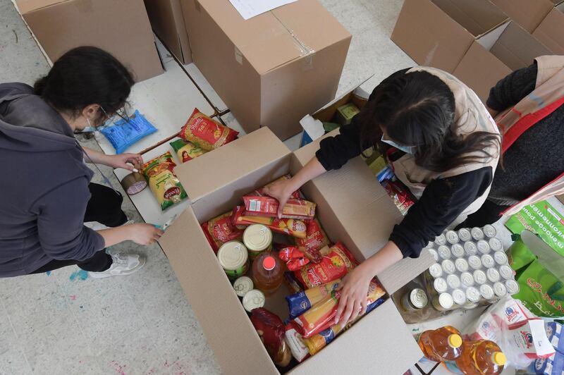 Members of Tunisian Red Crescent prepare food packages for the elderly and low-income families in the coastal town of Ezzahra near Tunis. AFP