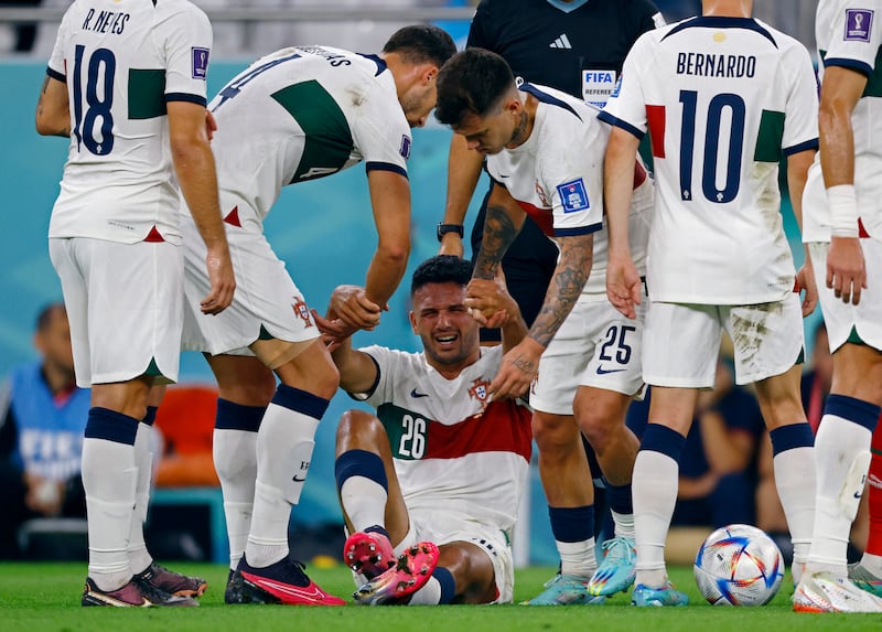 Portugal's Goncalo Ramos is helped up by Ruben Dias and Otavio. Reuters