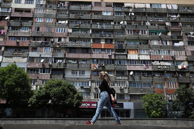 A woman passes next to a building apartment in Yerevan, Armenia. Thanassis Stavrakis / AP Photo