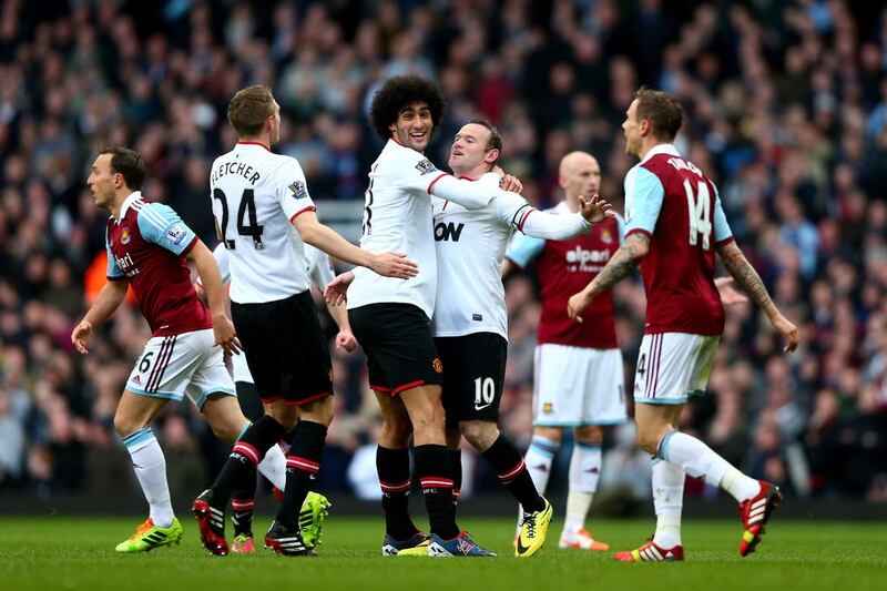 Wayne Rooney of Manchester United is congratulated by teammate Marouane Fellaini of Manchester United after scoring the opening goal with a long range shot on Saturday. Paul Gilham / Getty Images / March 22, 2014