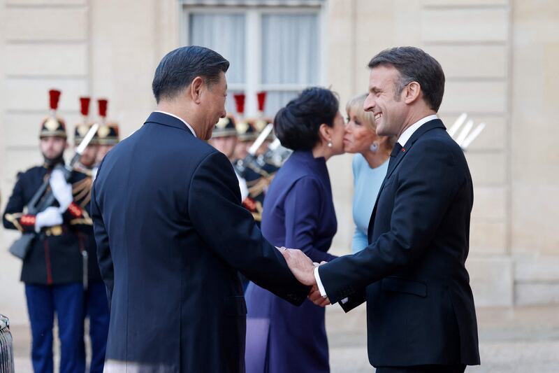 French President Emmanuel Macron, his wife Brigitte Macron, Mr Xi and Ms Peng greet each other before the state dinner. AFP