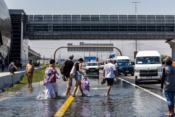 People walk through floodwater on Sheikh Zayed Road. AP