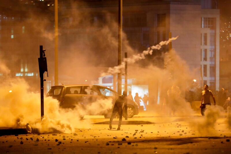 Lebanese demonstrators hurl tear-gas canisters back at riot police during clashes in the capital Beirut on December 14, 2019. AFP