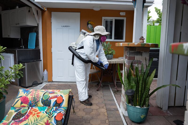 Margine Rodriguez, a Mosquito control inspector, sprays a pesticide to kill mosquitos in Miami. Getty Images