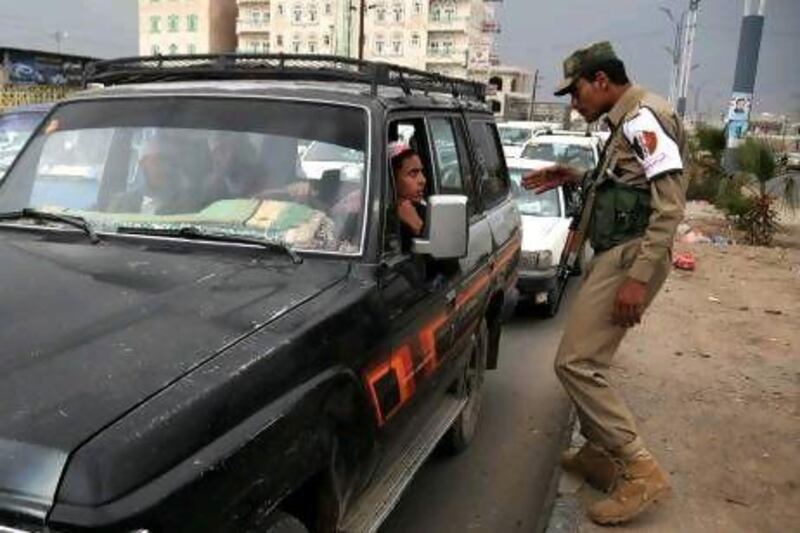 A Yemeni soldier inspects a vehicle at a checkpoint as authorities tighten up security measures in Sanaa yesterday after flights were suspended at the capital's airport.