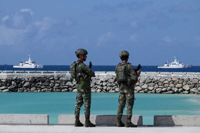 Philippine soldiers look at coast guard vessels near Thitu Island in the South China Sea on December 1. AFP