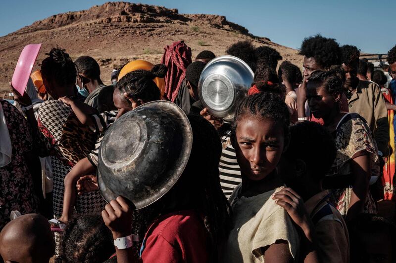 (FILES) In this file photo taken on December 12, 2020 Ethiopian refugee children who fled the Ethiopia's Tigray conflict wait in a line for a food distribution by Muslim Aid at the Um Raquba refugee camp in Sudan's eastern Gedaref state. US President Joe Biden condemned the six-month conflict in Ethiopia's war-hit Tigray region May 26, 2021 calling for a ceasefire and declaring that human rights abuses "must end." / AFP / Yasuyoshi CHIBA
