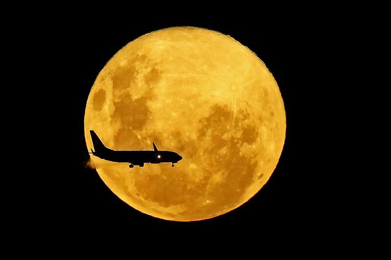 A plane passes in front of the full moon as seen from Curitiba, Brazil.  AFP