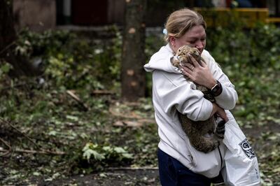 A woman holds her cat at the scene of an apartment block hit by a Russian missile in Kryvyi Rih. EPA