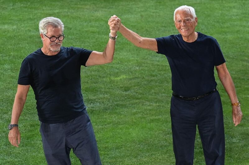 Designer Giorgio Armani, right, and Leo Dell'Orco acknowledge applause following the presentation of the spring / summer 2022 show. AFP