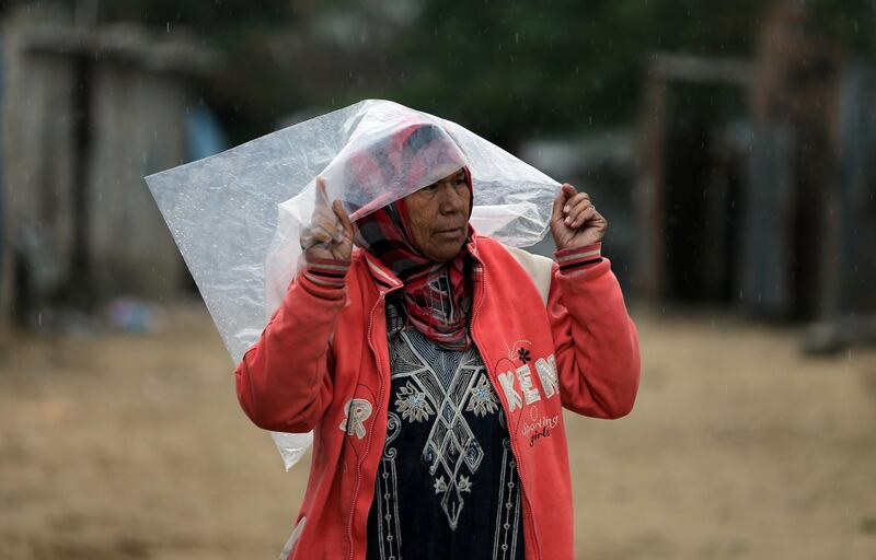 A Palestinian woman shelters from rain in Khan Younis in the southern Gaza Strip. Reuters