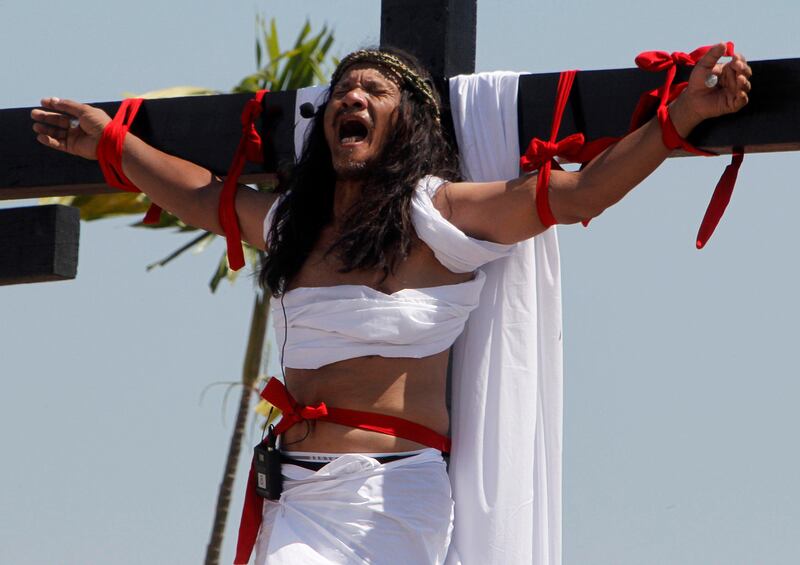 Ruben Enaje, 52, who is portraying Jesus Christ for the 27th time, screams as he hangs on a wooden cross during a Good Friday crucifixion re-enactment in San Pedro Cutud town, Pampanga province, north of Manila March 29, 2013. The Roman Catholic church frowns on the gory spectacle held in the Philippine village of Cutud every Good Friday but does nothing to deter the faithful from emulating the suffering of Christ and taking a painful route to penitence.  Holy Week is celebrated in many Christian traditions during the week before Easter.  REUTERS/Romeo Ranoco (PHILIPPINES - Tags: RELIGION SOCIETY) *** Local Caption ***  RVR13_PHILIPPINES-_0329_11.JPG