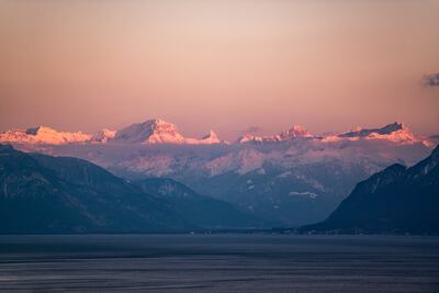 Sunset over the snowy Alps with Lake Geneva in the foreground. Photo: Unsplash