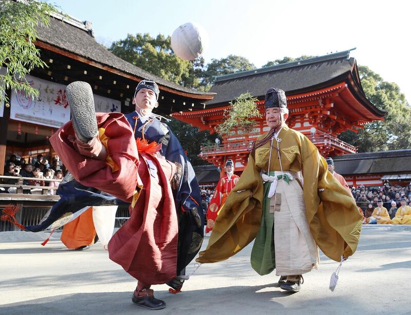 People clad in ancient Kimono attire kick a traditional deer-skin ball during the Kemari Hajime ceremony at the Shimogamo shrine in Kyoto.  AFP