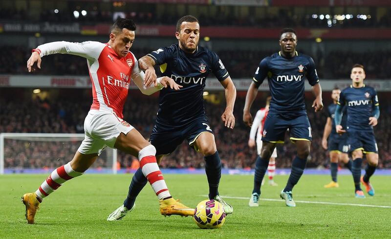 Arsenal's Alexis Sanchez dribbles past Southampton defender Ryan Bertrand during his side's 1-0 Premier League victory on Wednesday. Andy Rain / EPA / December 3, 2014 