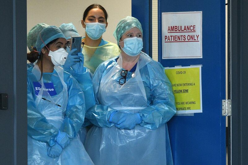 NHS workers wearing PPE (personal protective equipment), including a face mask, gloves and aprons, as a precautionary measure against COVID-19, prepare to participate in a national "clap for carers" to show thanks for the work of Britain's NHS (National Health Service) workers and other frontline medical staff around the country as they battle with the novel coronavirus pandemic, at Aintree University Hospital in Liverpool, north west England on May 14, 2020. - Britain on Thursday said it was in discussions with Swiss pharma giant Roche to mass purchase its coronavirus antibody test after scientists claimed it was "100 percent" accurate. "This test developed by Roche appears to be extremely reliable, it's got the green light from testers," health minister Edward Argar told the BBC on Thursday. (Photo by Oli SCARFF / AFP)