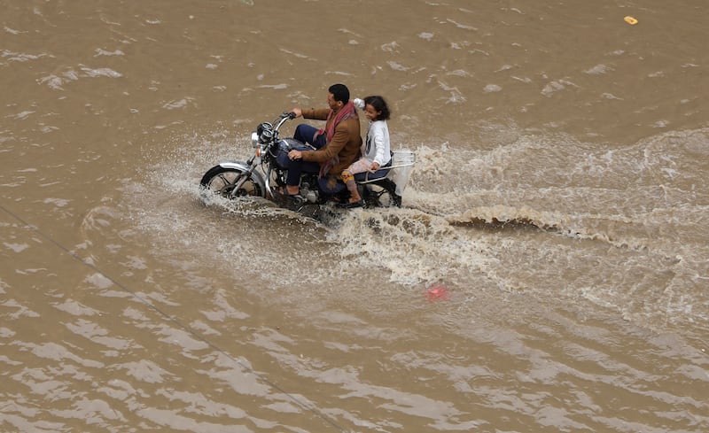 A motorbike ploughs through floodwater in Sanaa. Reuters