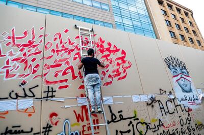 Lebanese graffiti artist draw murals and slogans on the wall of the headquarters of the United Nations Economic and Social Commission for Western Asia (UN-ESCWA), in the centre of the capital Beirut on October 25, 2019, on the ninth day of protest against tax increases and official corruption.  / AFP / ANWAR AMRO
