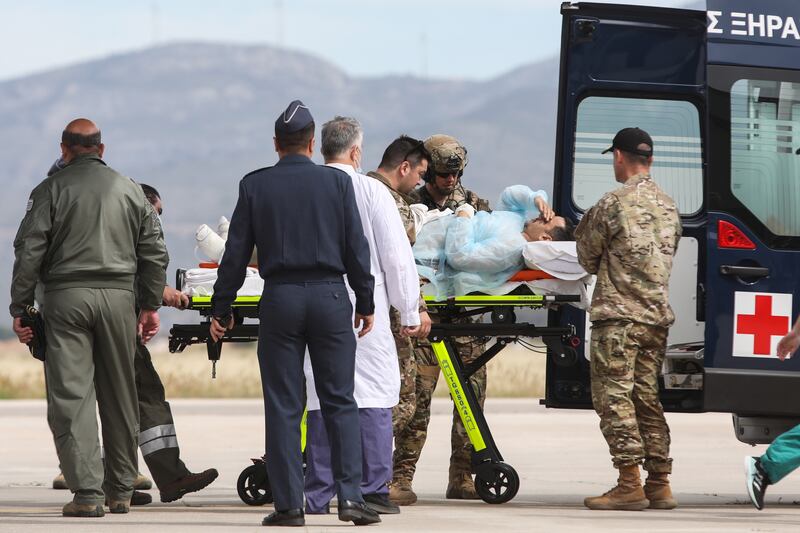 Soldiers attend to Greek citizens evacuated from Sudan as they disembark from a military aircraft in Attica, Greece. EPA