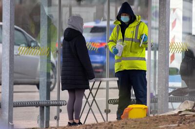 BRISTOL, ENGLAND - MARCH 1: A worker speaks to a member of the public at a temporary coronavirus testing centre at the Mall Coach Park on March 1, 2021 in Bristol, England. Testing efforts were expanded in South Gloucestershire after three returning residents were recently found to have been infected with a covid-19 variant first discovered in Brazil, which officials worry is more contagious than the dominant covid-19 strain. Three other travelers to Scotland also tested positive for the Brazil variant. (Photo by Matthew Horwood/Getty Images)