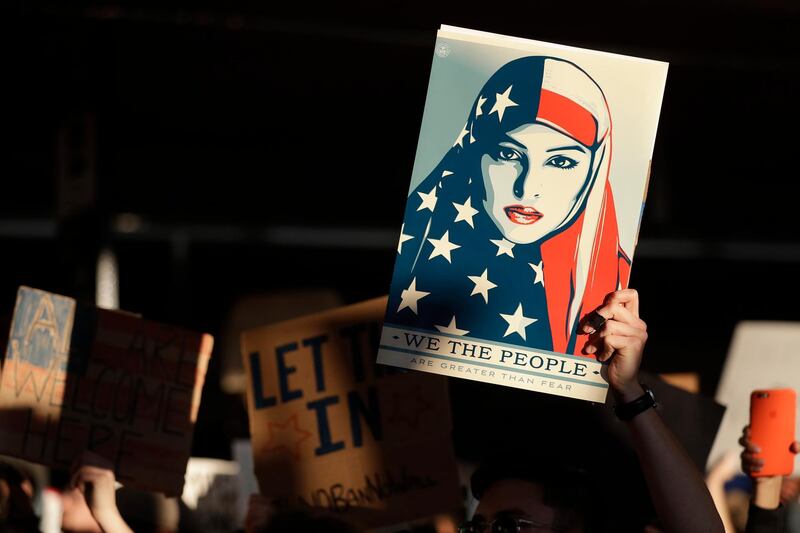 A protester holds a sign at San Francisco International Airport during a demonstration to denounce President Donald Trump's executive order that bars citizens of seven predominantly Muslim-majority countries from entering the U.S. Saturday, Jan. 28, 2017, in San Francisco. (AP Photo/Marcio Jose Sanchez)