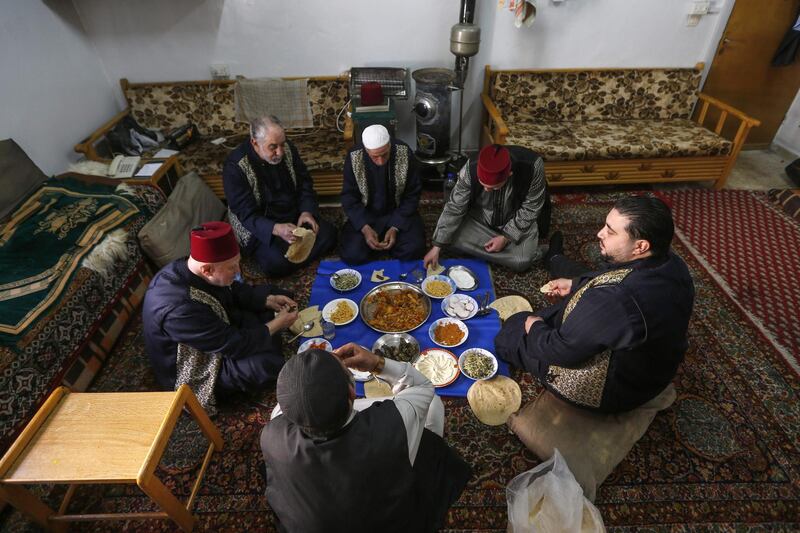 Muezzins share a meal in a room at the Umayyad Mosque in the ancient quarters of Damascus. AFP