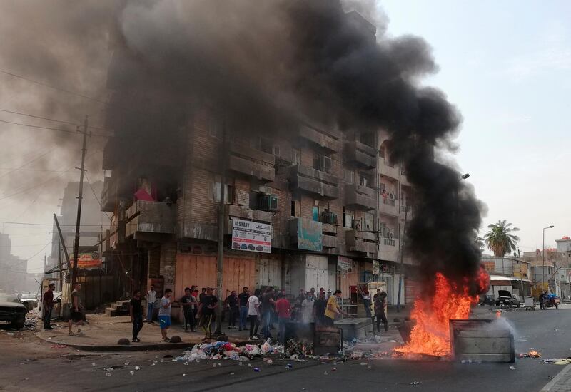 Anti-government protesters set a fire and block roads in Baghdad. AP Photo