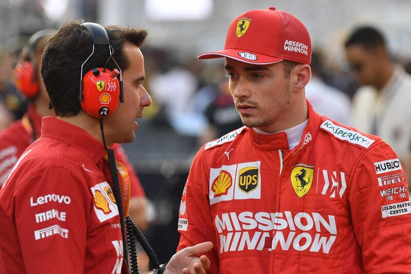 Ferrari's Monegasque driver Charles Leclerc (C) chats with an engineer on the grid at the Yas Marina Circuit in Abu Dhabi, ahead of the final race of the season, on December 1, 2019. / AFP / ANDREJ ISAKOVIC
