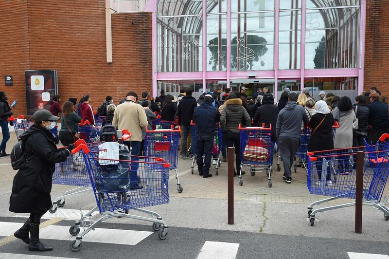 People queue at the entrance to a supermarket in Montpellier, one day after the local prefect announced that the number of customers would be limited to 100 inside supermarkets to prevent the spread of the Covid-19. Sylvain Thomas / AFP