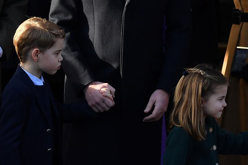 Britain's Prince George of Cambridge, left, and Britain's Princess Charlotte of Cambridge leave after the Royal Family's traditional Christmas Day service at St Mary Magdalene Church. AFP