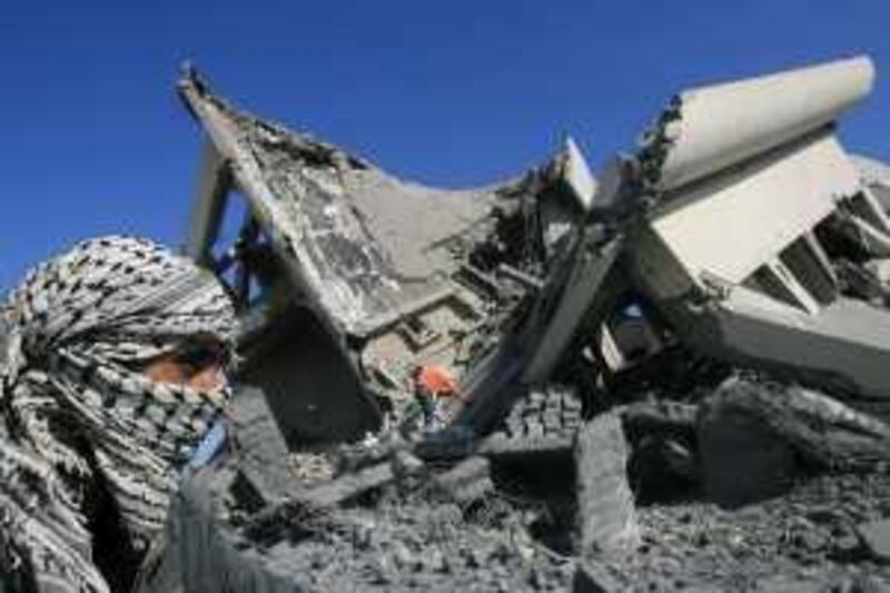 A Palestinian inspects the rubble of a building after an Israeli air strike on Friday in Rafah, southern Gaza Strip, Saturday, March 20, 2010. Friday's missiles hit the defunct international airport in southern Gaza and tunnels dug by militants near the border with Israel. Hamas officials say Israeli aircrafts fired five missiles at Gaza's defunct airport and nearby border tunnels, wounding at least 12 people. (AP Photo/ Eyad Baba) *** Local Caption ***  TTW101_APTOPIX_MIDEAST_ISRAEL_PALESTINIANS.jpg