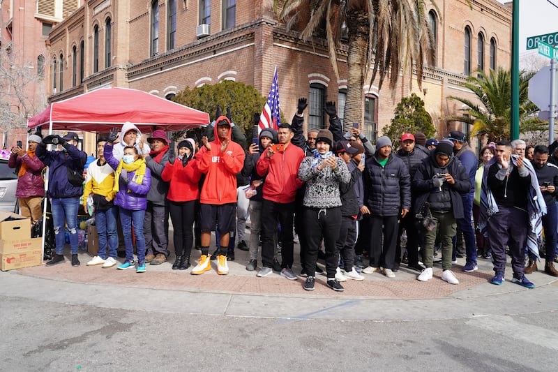 A group of migrants gather outside the Sacred Heart Church in El Paso to cheer on protesters. Willy Lowry / The National