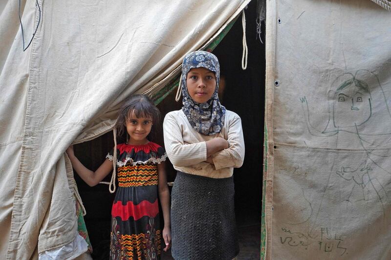 Young girls stand through the entrance of a tent at the Suweida camp for people internally displaced by conflict, near Yemen's northern city of Marib. AFP