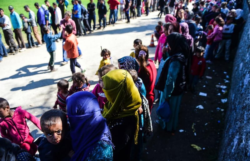 Migrants and refugees wait in the line for food distribution in the makeshift camp at the Greek-Macedonian border, near the Greek village of Idomeni. Bulent Kilic / AFP Photo
