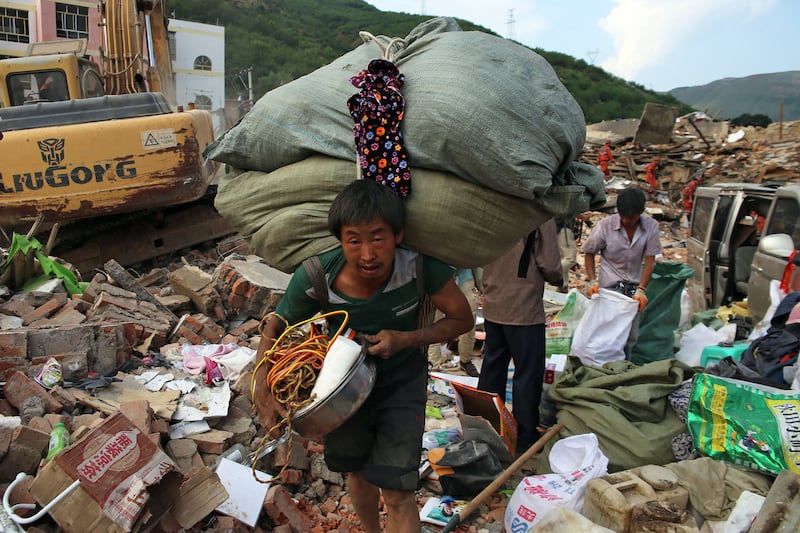 A survivor carries his belongings in Longtoushan, in China's Yunnan province, after an earthquake shook the country's south-west in August 2014, killing several hundreds