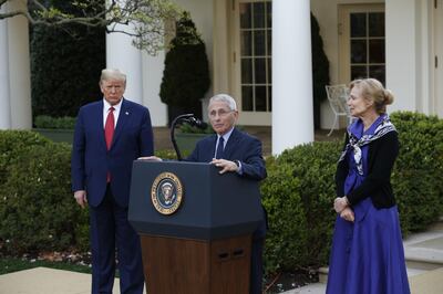 Anthony Fauci, director of the National Institute of Allergy and Infectious Diseases, center, speaks as U.S. President Donald Trump, left, and Deborah Birx, coronavirus response coordinator, listen during a Coronavirus Task Force news conference in the Rose Garden of the White House in Washington, D.C., U.S., on Sunday, March 29, 2020. Trump said his administration expects the peak of deaths in the U.S. coronavirus outbreak to be reached in about two weeks, and that he would extend guidelines for Americans to distance themselves from one another until April 30. Photographer: Stefani Reynolds/CNP/Bloomberg